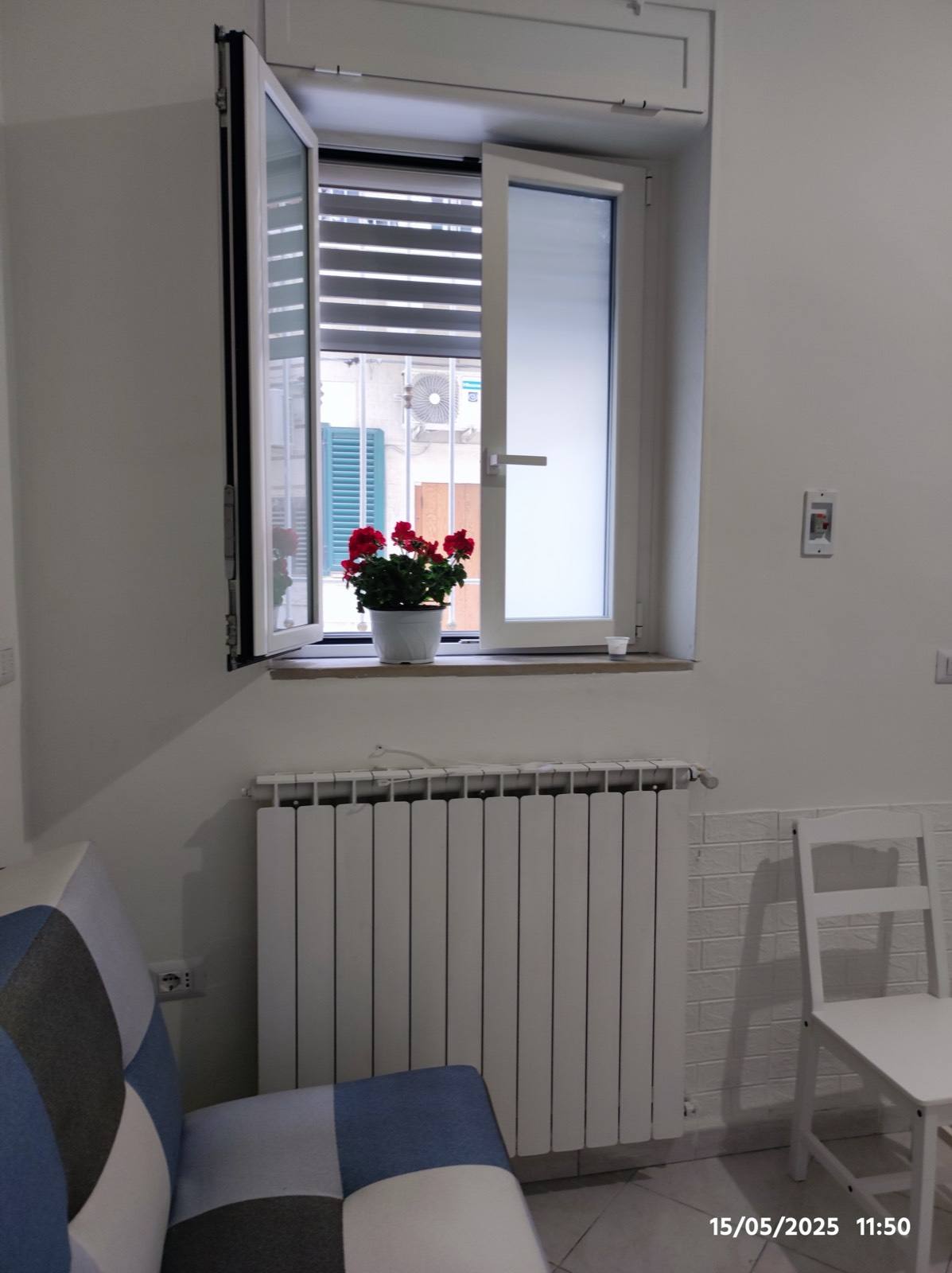 Finestra con gerani e angolo divano — Casa Amore